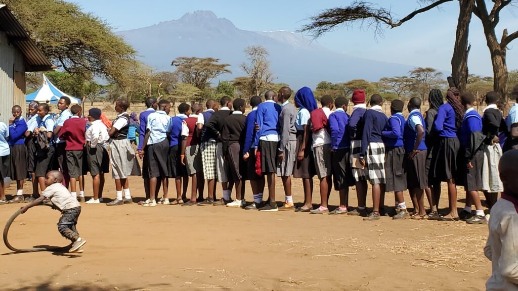 KKIS students line up for lunch: Here, the Keep Kids in School lined up for the meal. They were treated as special guest by given them their own buffet. The students come from twenty- nine different schools in Rombo, and they felt honored to be given the opportunity to acknowledge and meet other KKIS-supported students from other schools.